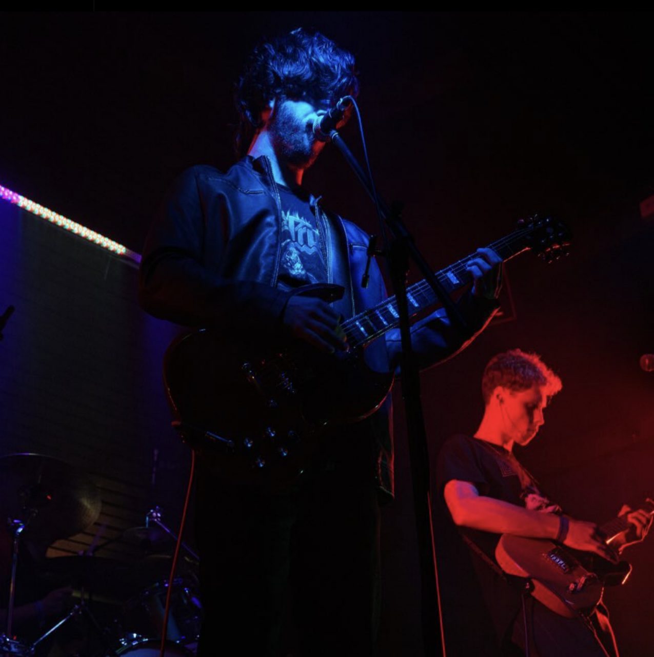 Two guitarists lit in blue and red